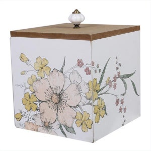 May include: A white wooden box with a floral design. The box has a hinged lid with a white ceramic knob. The floral design features pink, yellow, and green flowers.