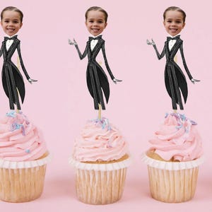 May include: Three cupcakes with pink frosting and colorful sprinkles topped with a black and white cartoon character wearing a tuxedo. The character's head is replaced with a photo of a person.