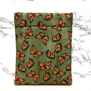 May include: A green fabric pouch with a zipper closure and a pattern of orange butterflies.