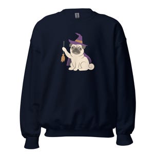 Könnte beinhalten: Ein marineblaues Sweatshirt mit Rundhalsausschnitt und einem Grafikdruck eines hellen Mopses, der einen violetten Hexenhut und einen Umhang trägt. Der Mops hält einen kleinen braunen Besen in seiner rechten Pfote. Das Motiv ist mittig platziert.