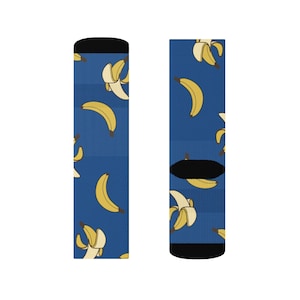 Könnte beinhalten: Blaue Socken mit einem Muster aus gelben Bananen. Die Socken haben schwarze Bündchen und Zehen. Die Bananen sind ganz und geschält dargestellt.