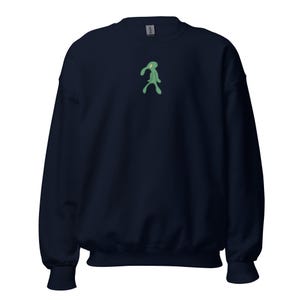 Peut inclure: Sweat-shirt bleu marine avec un personnage de dessin animé vert brodé sur la poitrine. Le sweat-shirt a un col rond et des manches longues avec des poignets côtelés. Le tissu semble doux et confortable, adapté aux tenues décontractées.