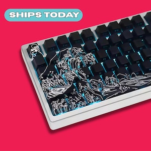 May include: A mechanical keyboard with black keycaps and a white frame. The keyboard features a custom design of a Japanese wave pattern in black and white. The text "SHIPS TODAY" is in a blue box.