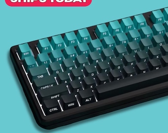 Puede incluir: Un teclado mecánico negro con teclas de color turquesa y negro. Las teclas están dispuestas en un diseño estándar, con teclas de función y un teclado numérico. El teclado tiene un diseño elegante y moderno. El texto "SHIPS TODAY" está en un óvalo rojo.