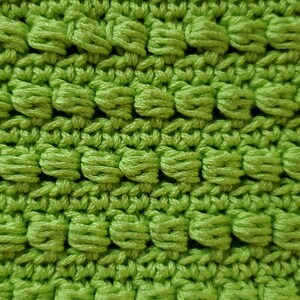 Pu&ograve; includere: Primo piano di un tessuto lavorato a uncinetto verde con una superficie testurizzata e irregolare.