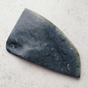 Op de afbeelding: Een donkergroene en zwarte steen met een marmerpatroon. De steen is glad en gepolijst.