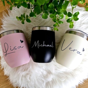 Könnte beinhalten: Drei weingläser ohne Stiel in Rosa, Schwarz und Creme. Jedes Glas hat einen silbernen Rand und einen Namen in Schreibschrift: Lisa, Michael und Vera. Ein kleines Herz begleitet die Namen von Lisa und Vera.