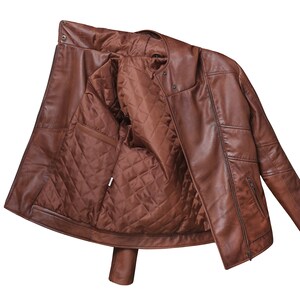 May include: A brown leather jacket with a quilted lining. The jacket is unzipped and turned inside out, showing the lining.