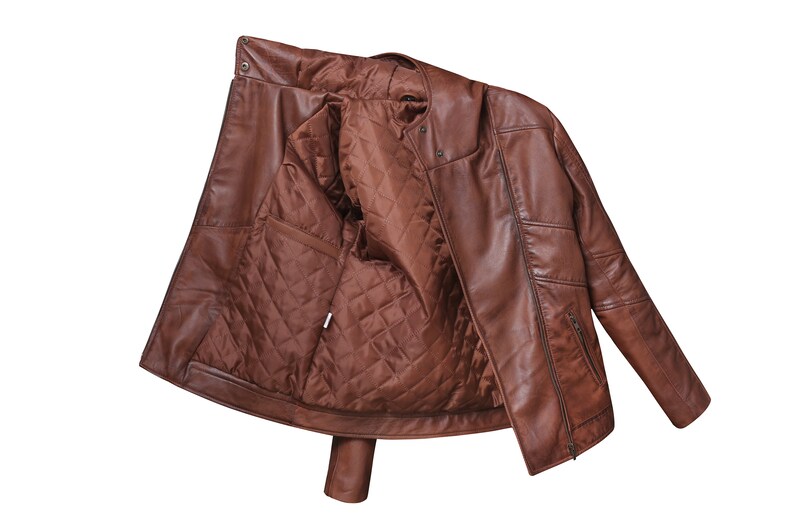 May include: A brown leather jacket with a quilted lining. The jacket is unzipped and turned inside out, showing the lining.