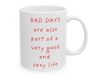 以下が含まれることがあります： 赤い文字で「BAD DAYS are also part of a very good and sexy life」と書かれた白いセラミックマグ。 マグカップは湾曲したハンドルと光沢のある仕上げが特徴です。 動機付けとユーモアのあるギフト。