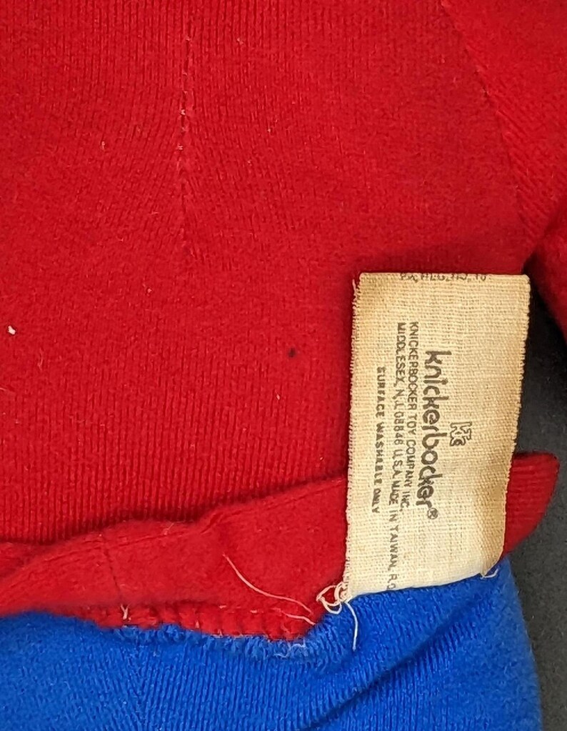A red sweater with a label attached to it, which appears to be a knickerbocker toy.