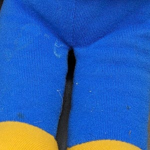 A close-up view of a pair of blue and yellow pants, with a red top visible.