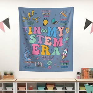 May include: A blue wall tapestry with the words "IN MY STEM ERA" in colorful, bubble letters. The design includes science-themed illustrations like a microscope, rocket, and lightbulb, along with phrases such as "Ideas in Action" and "Fueling Bright Minds."