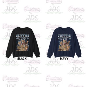 May include: Two sweatshirts with a graphic print of a group of cats with the text "SHEEBA The Bengal" in a blue and white font. The sweatshirt on the left is black and the sweatshirt on the right is navy blue.