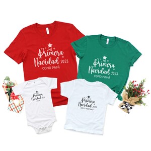 May include: Three white t-shirts with the text "Mi Primera Navidad 2023" in black. The shirts are decorated with a star and the words "Como Papa", "Como Mama", and "Como Hermano".