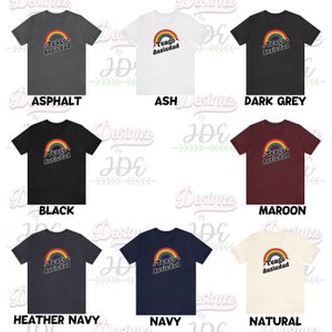 May include: A set of ten t-shirts in various colors featuring a rainbow graphic with the text "Tengo Ansiedad" in black. The colors include asphalt, ash, dark grey, black, maroon, heather navy, navy, and natural.