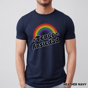 May include: A navy blue t-shirt with a rainbow and the text "Tengo Ansiedad" in black.