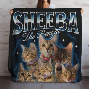 May include: A black fleece blanket with a blue and white graphic of the word "SHEEBA" with the text "The Bengal" underneath. The blanket features a collage of six Bengal cats with different markings and poses.