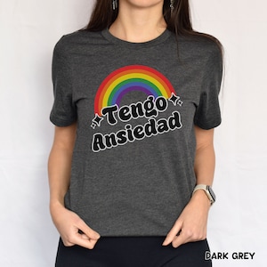 May include: A dark grey t-shirt with a rainbow and the text "Tengo Ansiedad" in black.