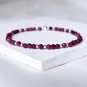 May include: A delicate bracelet made with small, faceted purple gemstones and silver beads.