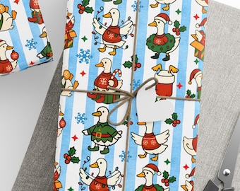 May include: Wrapped gifts with festive duck-themed wrapping paper. The paper features ducks in holiday attire on a blue and white striped background. Each gift is tied with twine and adorned with a white tag. A ball of twine and scissors are also visible.