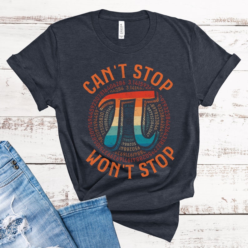May include: A dark blue t-shirt with a vintage-style graphic of the mathematical constant pi. The graphic features a rainbow color scheme and the text "Can't Stop Won't Stop".