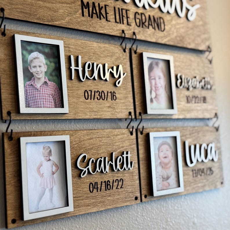 Op de afbeelding: Houten fotodisplay voor het gezin met de tekst "Make Life Grand" bovenaan. De display heeft vier fotolijsten met namen en data. De namen Henry, Scarlett, Elijah en Luca worden in een sierlijke letter weergegeven.
