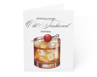 以下が含まれることがあります： 「Wishing you an Old Fashioned birthday」というテキストと、チェリーを添えたオールドファッションドカクテルの絵が描かれたグリーティングカードです。