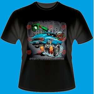 May include: Black t-shirt featuring a cartoon graphic of a blue Camaro hot rod with flames, a green zombie hand, and the text "CAMARO". The text "STICK IT TO THE COMPETITION!" is also included.