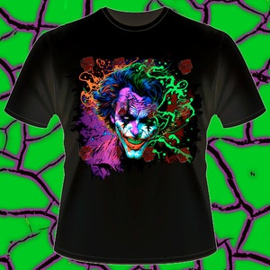 May include: Black t-shirt with a colorful graphic print of the Joker's face. The graphic is in shades of purple, blue, green, and orange.