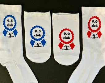 May include: White athletic socks featuring blue and red ribbon designs. The blue ribbons say "9.5 club" and the red ribbons say "9.0 club". Each ribbon has a gymnast silhouette.