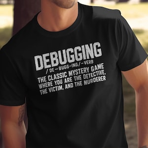 May include: A black short-sleeved t-shirt featuring white text that reads: DEBUGGING / DE-BUGG-ING / -VERB THE CLASSIC MYSTERY GAME WHERE YOU ARE THE DETECTIVE, THE VICTIM, AND THE MURDERER. The design is printed in a distressed, weathered white font.