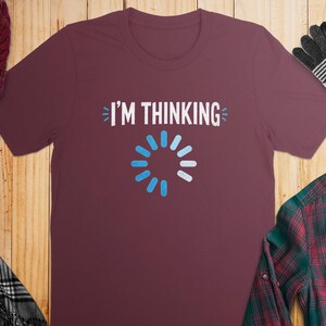 Maroon t-shirt with white "I'M THINKING" text and loading icon.