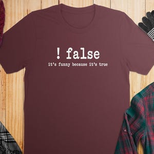 Maroon t-shirt with white text "! false it's funny because it's true".