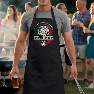 May include: Black apron featuring a white Mexican eagle design and the text "Estados Unidos Mexicanos El Jefe".