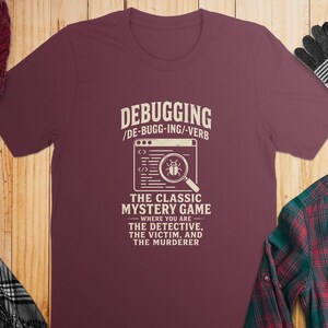 Maroon t-shirt with "Debugging The Classic Mystery Game" text and bug graphic.