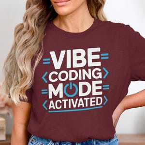 Maroon t-shirt with white text: "VIBE CODING MODE ACTIVATED".