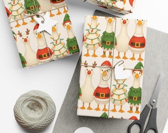 May include: Christmas-themed wrapping paper featuring cartoon geese in festive outfits. The geese are dressed as elves, Santa, and Christmas trees. The wrapped gifts are tied with twine and adorned with paper tags. A spool of twine and scissors are also present.