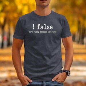 Dark grey t-shirt with white text: "! false, it's funny because it's true"