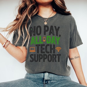 May include: Dark grey t-shirt with the text "NO PAY, ALL DAY TECH SUPPORT" in green and orange. The design includes a phone, laptop, and wifi symbol. The shirt is a casual wear item.