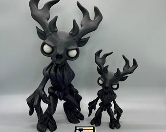 May include: Two black, detailed, resin figurines of deer-like creatures with antlers. The larger figurine is standing with its legs spread apart, while the smaller figurine is standing with its legs together. Both figurines have white eyes and a menacing expression.