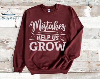 May include: Burgundy sweatshirt with white text that reads "Mistakes help us grow".