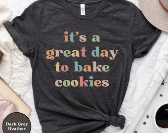 May include: Dark grey heather t-shirt with the text "it's a great day to bake cookies" in colorful letters.
