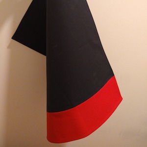 May include: A black and red fabric triangle with a red hem.