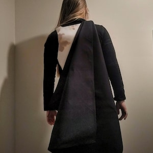 May include: A black long-sleeved shirt with a white and brown triangular design on the back.
