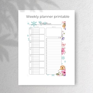 May include: A printable weekly planner with a floral design. The planner has a section for "This Week" and a section for "Objective". The floral design features pink, orange, and blue flowers with green leaves. The background is white with snowflakes.