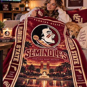 May include: A plush maroon and gold Florida State University throw blanket featuring the Seminoles logo, the Westcott Building, and the text "Florida State," "Seminoles," "Tradition Runs Deeper," "Fear the Spear," "Tallahassee, FL," and "Est. 1851."