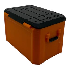May include: Orange plastic storage box with a black lid and a handle. The lid has a textured surface.