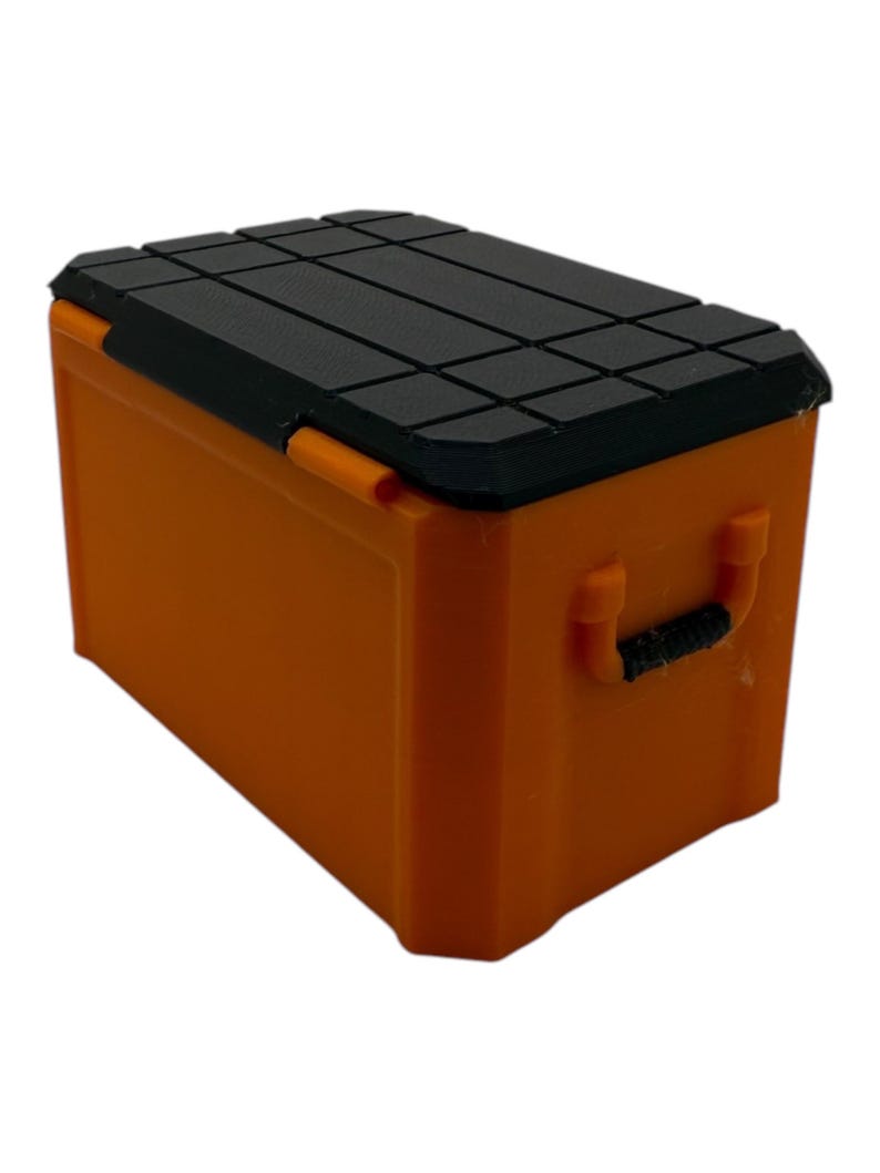 May include: Orange plastic storage box with a black lid and a handle. The lid has a textured surface.