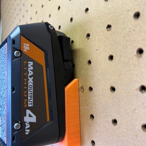 Puede incluir: Un soporte de bater&iacute;a de pl&aacute;stico naranja para una bater&iacute;a de litio negra y naranja de 18v MAX OUTPUT 4Ah.